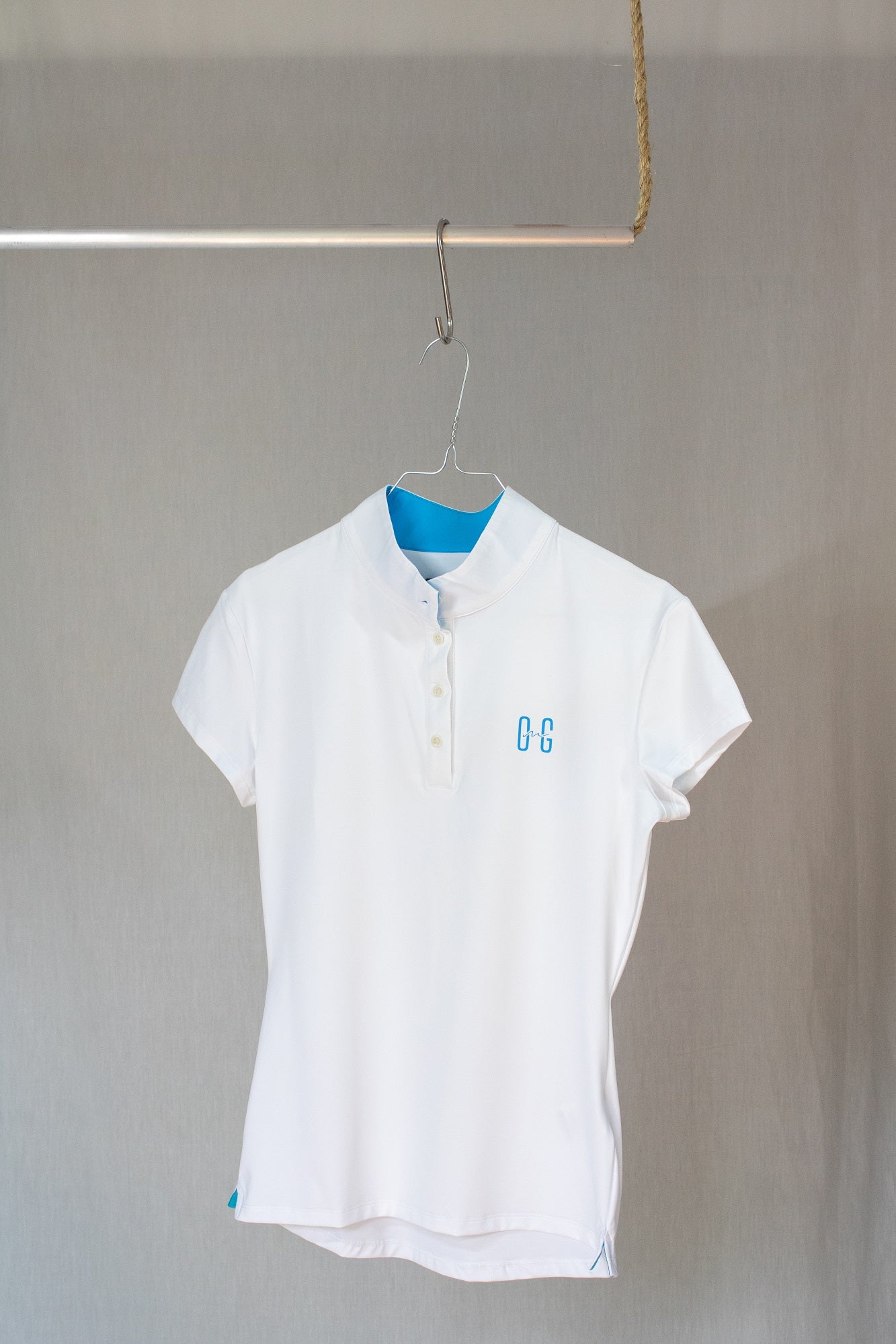 Image of Ocean Meets Green women's golf polo Moana in white on a hanger front view