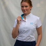 Full body image of Ocean Meets Green women's golf polo Moana in white worn by a woman